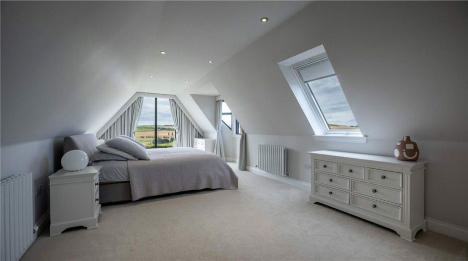 One of the bedrooms in the farmhouse near Inverurie featuring large skylights and floor to ceiling windows.