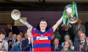 Kingussie captain James Falconer lifts the Camanachd Cup after victory against Oban Camanachd in the 2023 final. Image: Neil G Paterson.