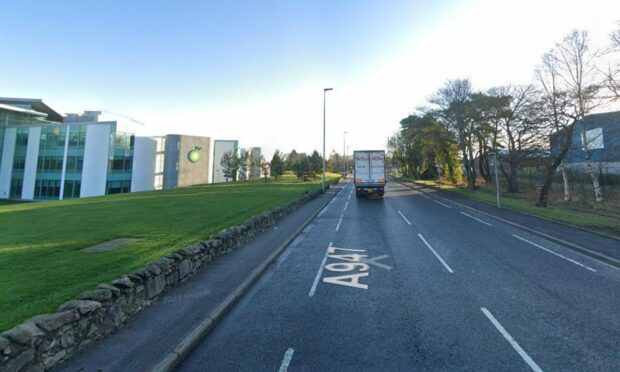 Stoneywood Road in Aberdeen, with BP offices and lorry driving on road.