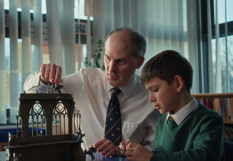 a male teacher builds a model cathedral with a student