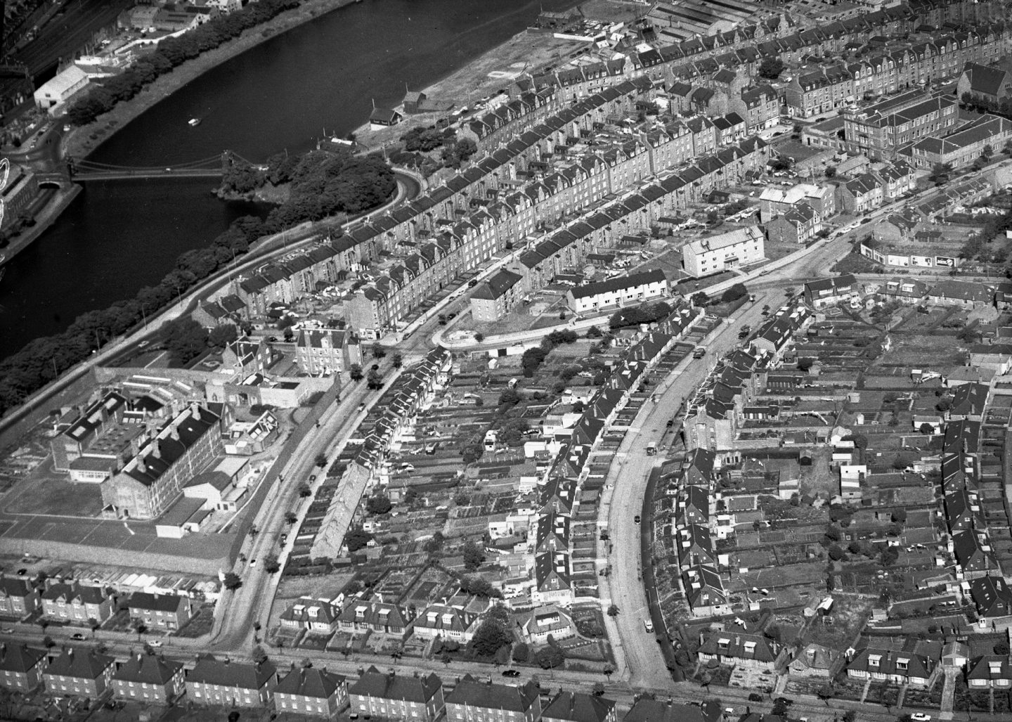 An aerial view of Torry looking east in 1968. The River Dee and the Wellington Suspension Bridge are on the left with Craiginches Prison at the bottom left and Walker Road School is at the top right.