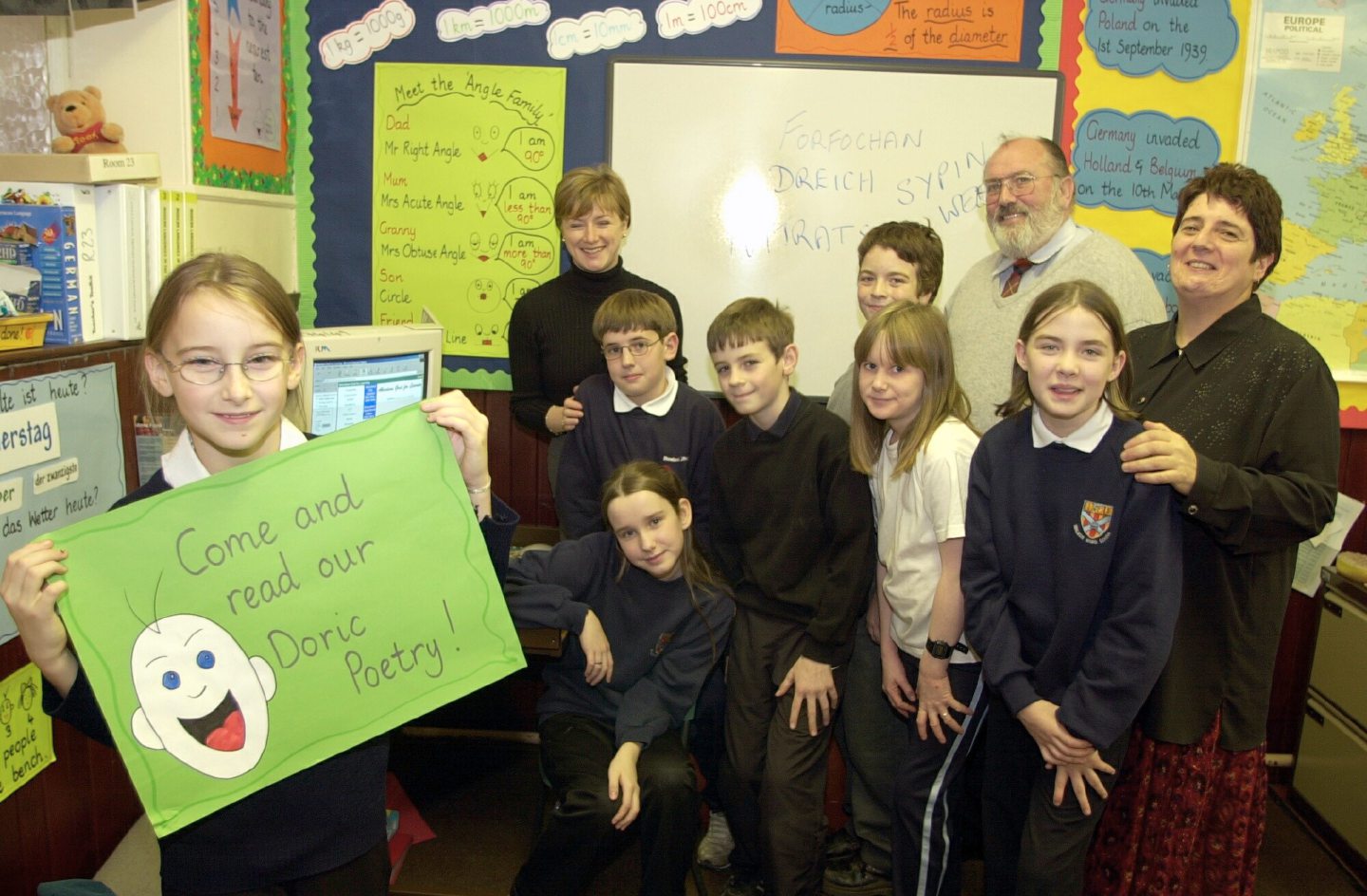 Group of P7 pupils hold an invitation for people to read their poetry on a Doric Website they put together with the help of site designers Les Wheeler and Sheena Blackwell in 2001.