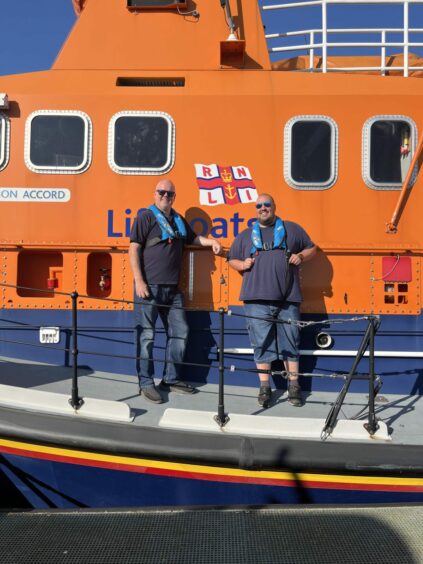 Cal Reed and Grant Bruce next to a RNLI lifeboat.