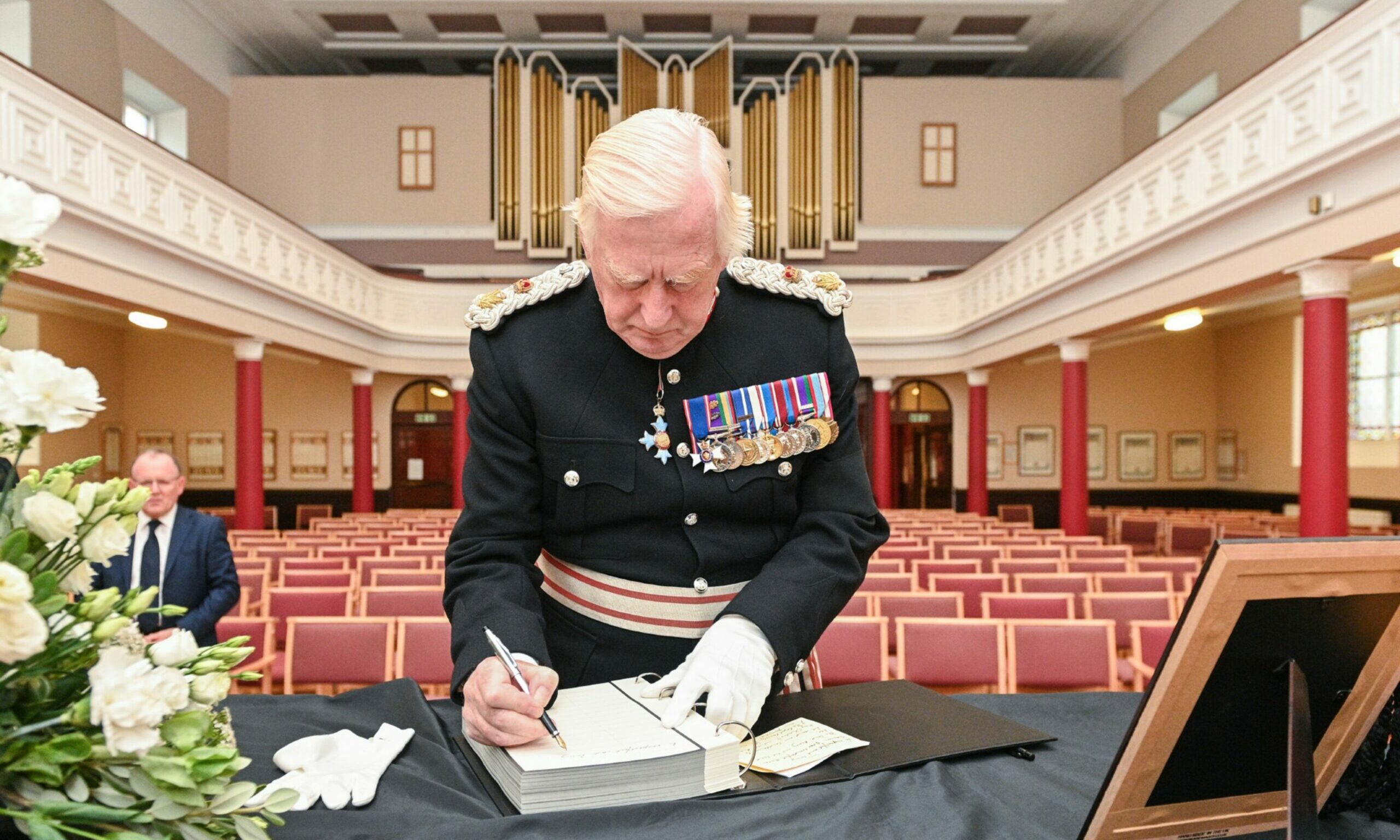 Looking from rear of St Giles Church at Moray Lord Lieutenant Seymour Monro in military uniform signing book of condolence.