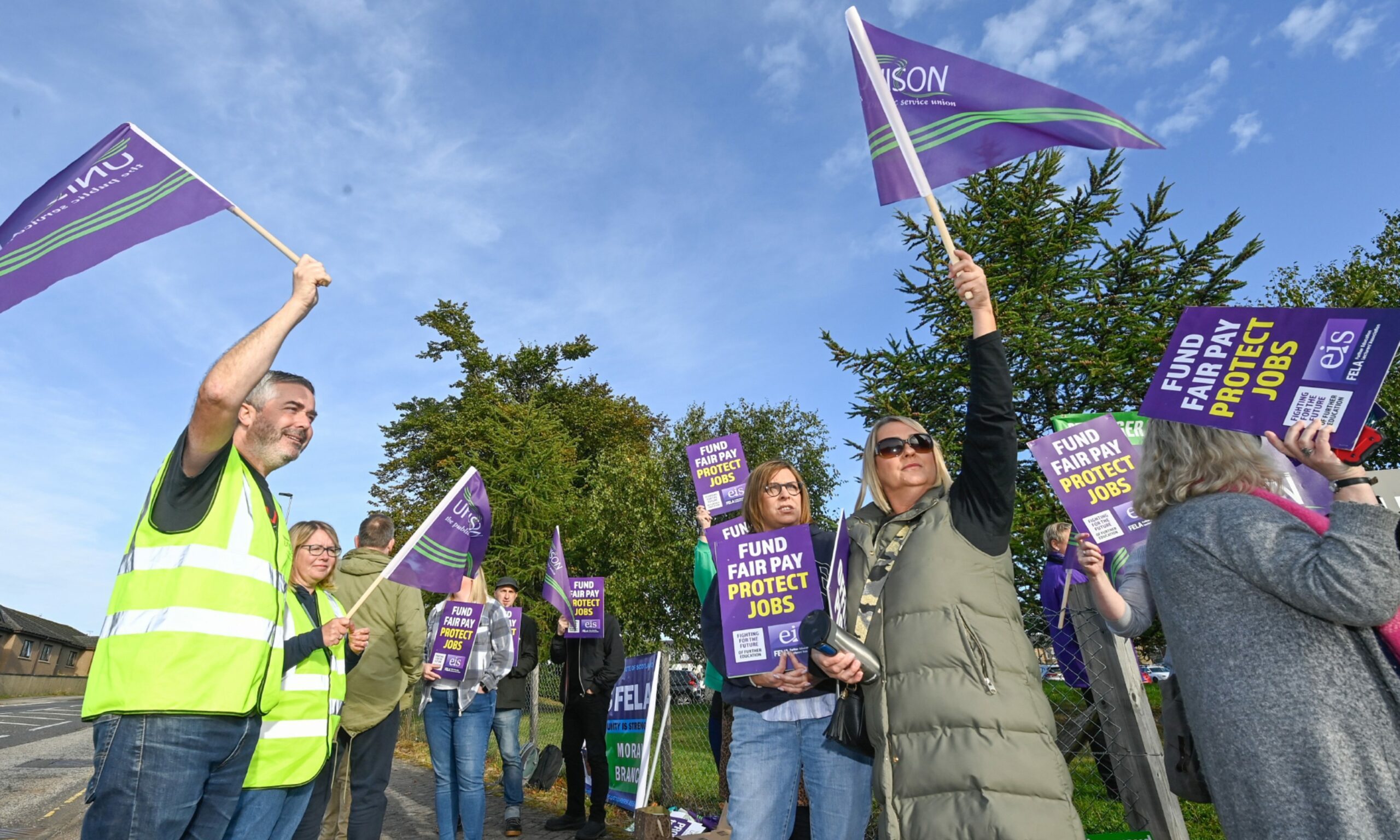 UHI Moray staff on the picket line waving Unison flags and banners.