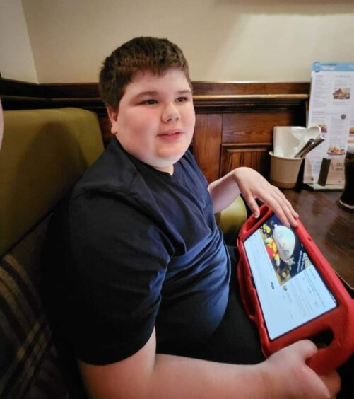 Thirteen-year-old Jack Petrie holding a tablet