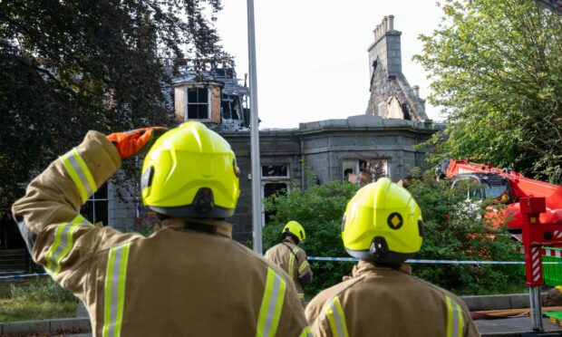 Firefighters look on to damaged building on Albyn Place