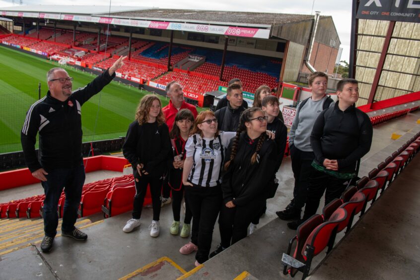 Tour guide Neil Gordon shows the group from Fraserburgh Academy what's what during their behind-the-scenes tour of Pittodrie