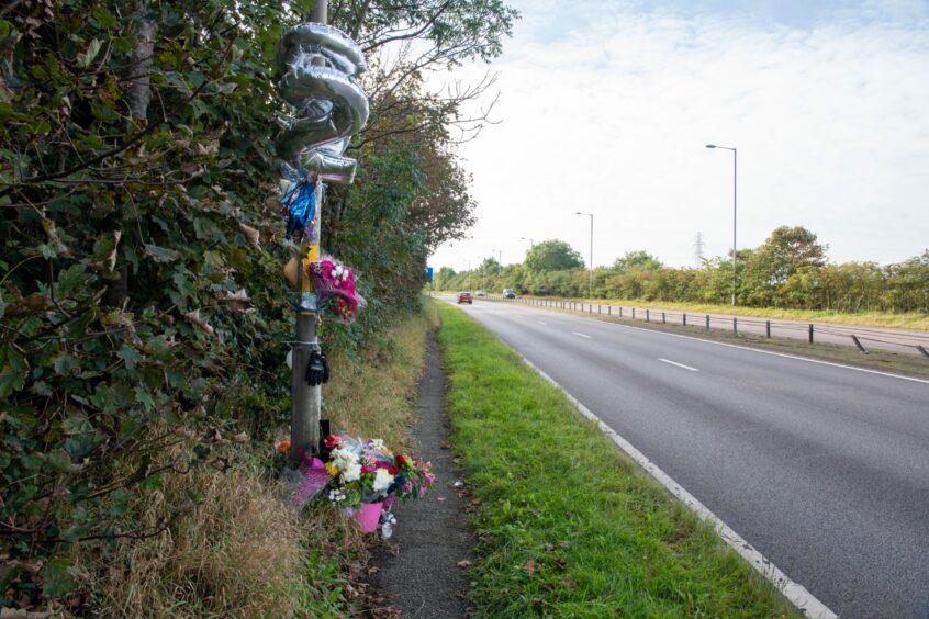 Balloons and flowers left at the roadside.