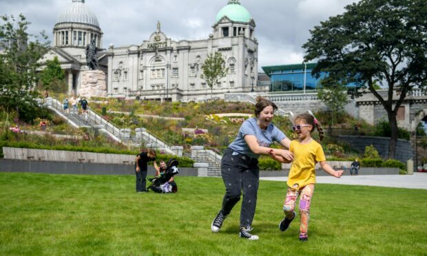 A young girl called Ava and her step-mum Jennifer Matthews playing on the grass at Union Terrace Gardens in Aberdeen