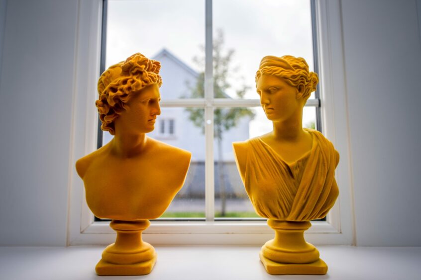 Two orange greek-inspired busts on a windowsill in the Cults interior designer's home