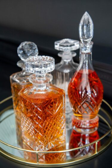 Crystal decanters on a gold-rimmed mirrored tray