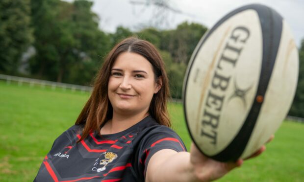 Coral-Ann Birnie from the Aberdeenshire Quines rugby club in Aberdeen holding out a rugby ball.