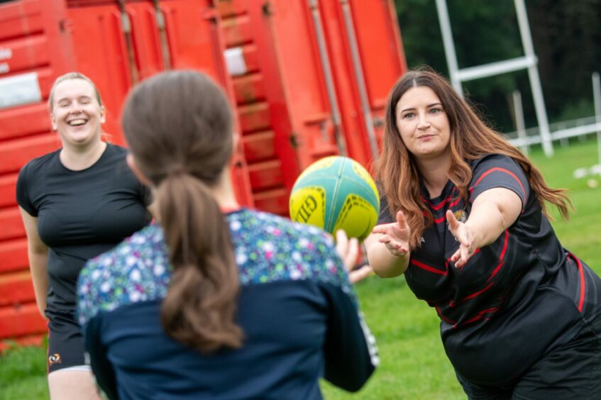 Coral-Ann passes the ball to another member of the Aberdeenshire Quines rugby club. 