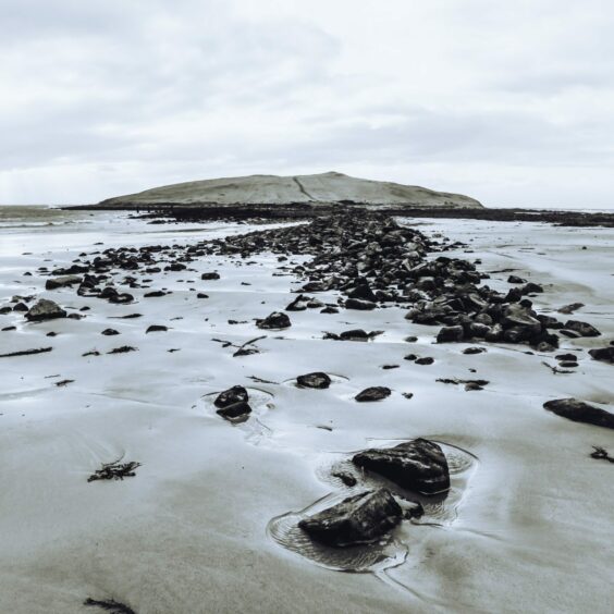 A black and white photo of the tidal island of Orasaigh, taken from a low angle.