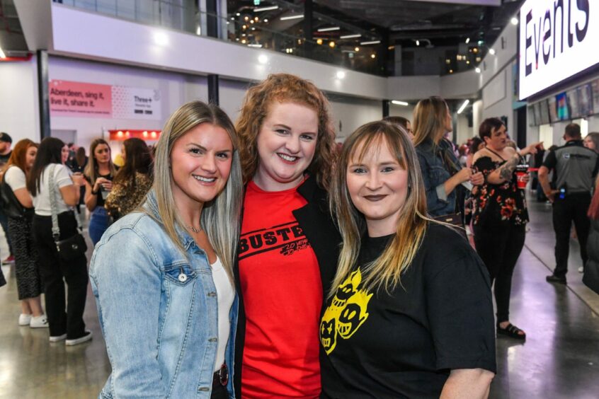 Three fans in the waiting area for Busted's Aberdeen show, two of them are wearing UK tour T-shirts