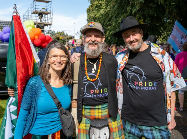 Group of Pride attendees in rainbow tartan.