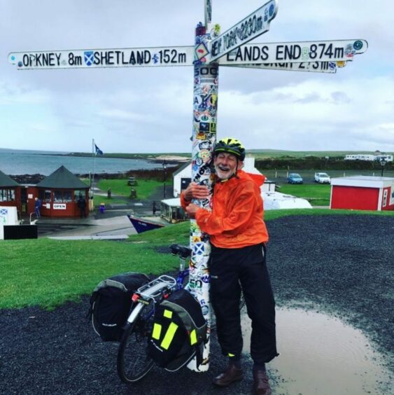 Peter Langford standing beside the iconic John O'Groats sign.