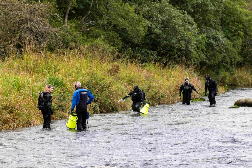 Volunteers searching along the banks of the River Dee