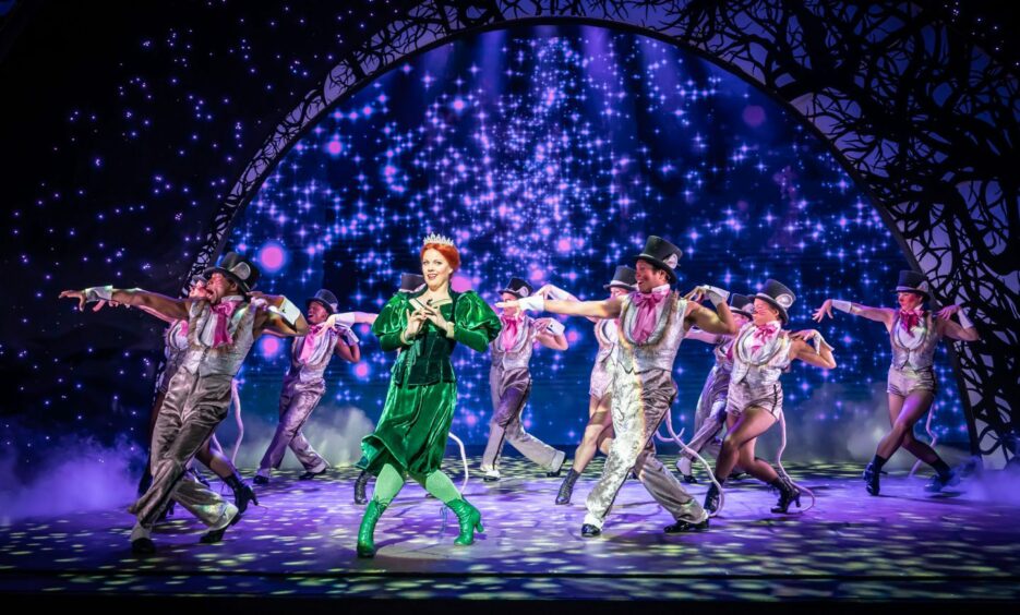 Joanne Clifton dancing on stage as Princess Fiona in Shrek the Musical with dancers behind her