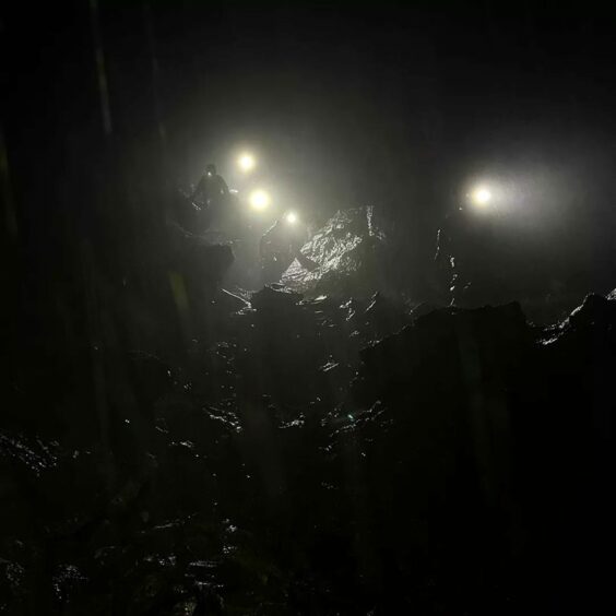 Rescue mountaineers navigate a large rock on the Skye mountain in the pitch black to reach a group of stranded walkers. 