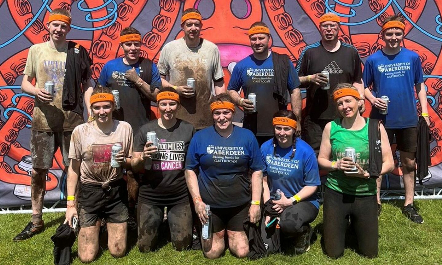 Group photo of muddy competitors after competing Tough Mudder. 