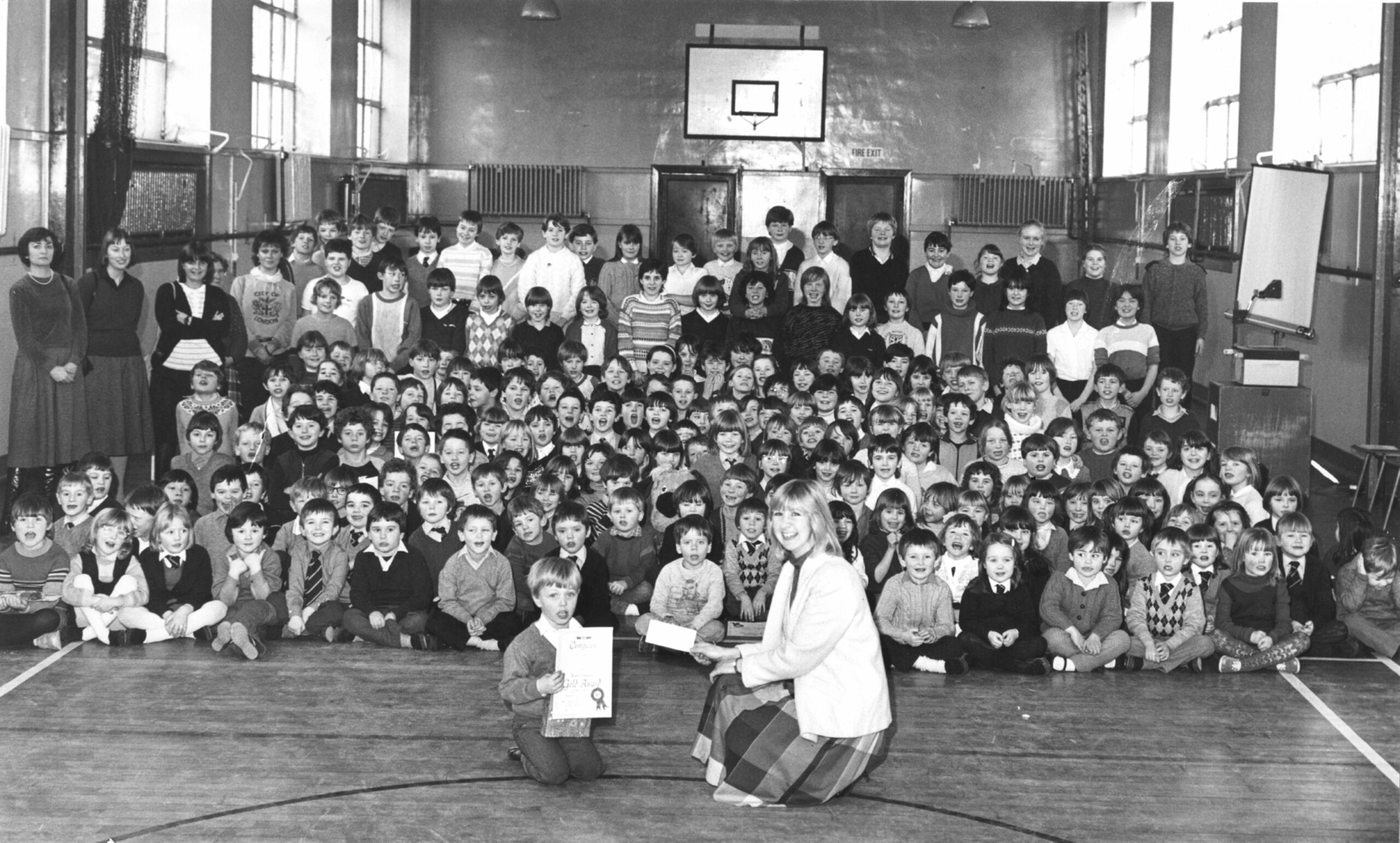 Young pupil presents money raised by the school for charity to Heather Roberts of the local Help the Aged branch in 1985.