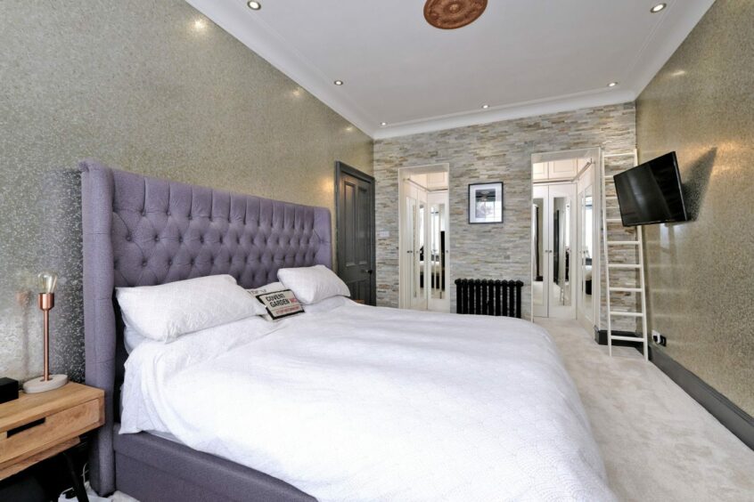 The master bedroom, with a double bed and wall-mounted TV