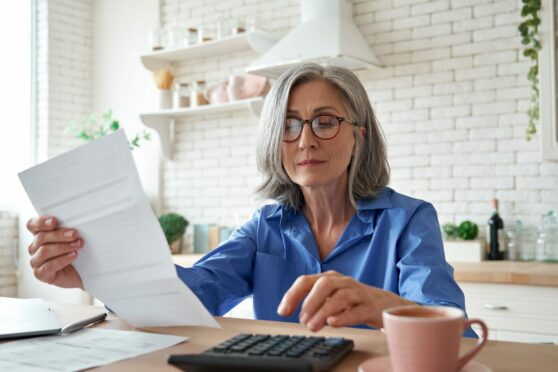 Woman looking at papers and doing sums.