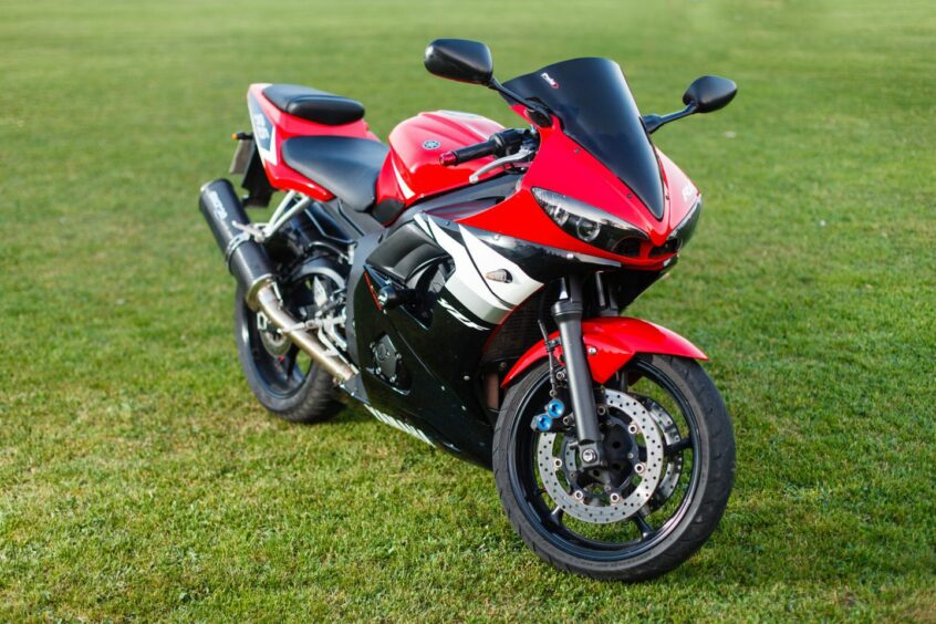 A Yamaha YZF-Rr in black and red livery with a smoked screen and chrome exhaust silencer.