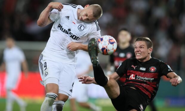 Stefan Gartenmann, right, challenges Blaz Kramer of Legia Warsaw for the ball during a Midtjylland match in the Europa Conference League. Image: Shutterstock.