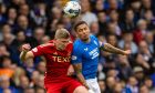 Jack Mackenzie of Aberdeen jumps with Rangers captain James Tavernier during a Premiership meeting at Ibrox in September.