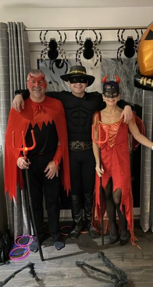 Adam and his parents in costumes for Halloween.
