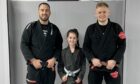 Pictures are three people in martial arts uniforms. Niamh Ross (centre) is one of Mikeysline's new Bee the Change champions. She is pictured here with SBG Moray coaches Martin Donaldson (left) and Kevin McAloon. Image: Mikeysline. Picture shows; Niamh Ross (centre) is one of Mikeysline?s new Bee the Change Champions. She is pictured here with SBG Moray coaches Martin Donaldson (left) and Kevin McAloon.