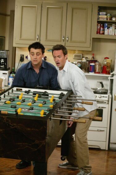Matthew Perry, who has now died, and Matt LeBlanc playing Chandler and Joey on the set of American sitcom Friends.