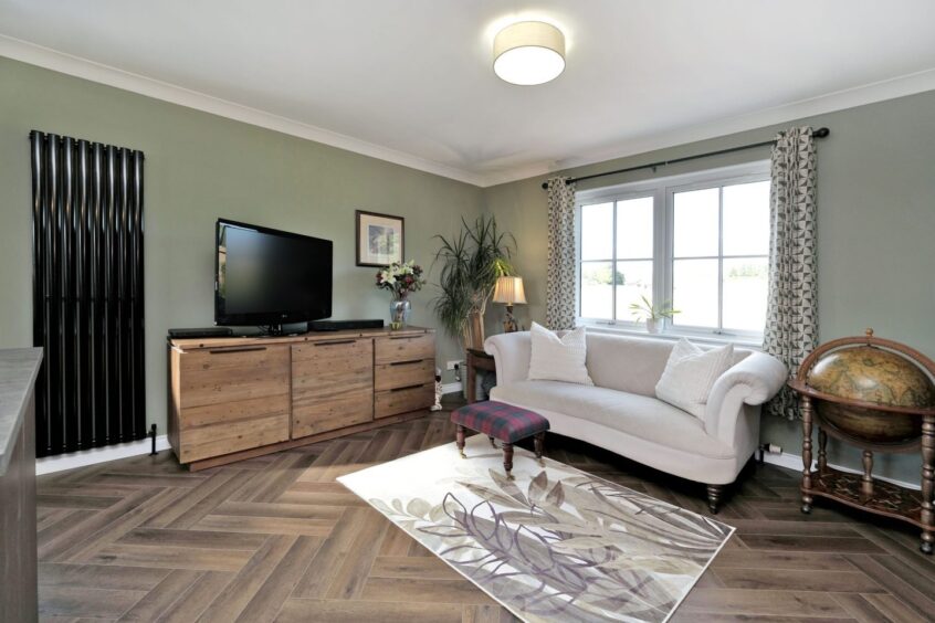 Stylish living area with herringbone flooring in the Drumlithie home renovation.
