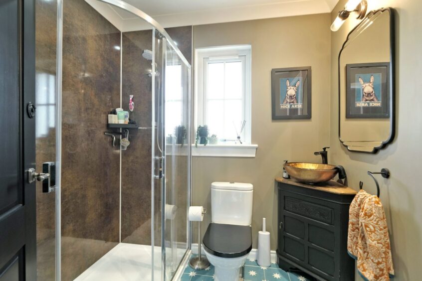 Luxurious bathroom with bronze effect shower, gold basin and black fittings inside the renovated Aberdeenshire home.