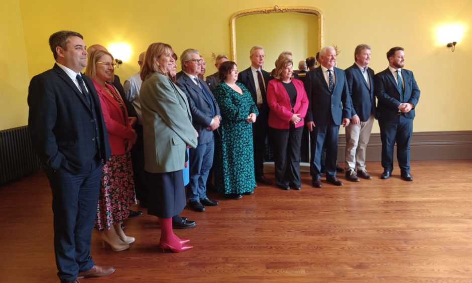 Michael Gove and the attendees of the Islands Forum pose for a group photo in a room in Lews Castle.