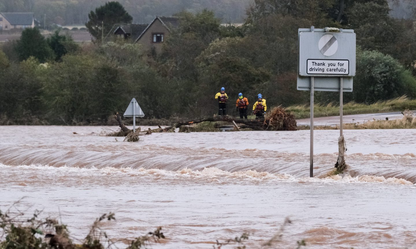 Wide shot of rescuers searching for a stranded driver in Marykirk with roads flooded due to Storm Babet.