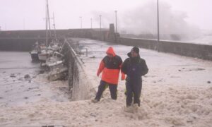 People braving the sea foam at Stonehaven harbour.
