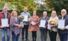 Line-up of foster carers holding flowers and awards.