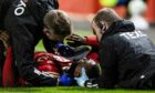 Aberdeen striker Duk  down after a head knock during the Europa Conference League match between Aberdeen and HJK Helsinki at Pittodrie Stadium. Image: SNS.