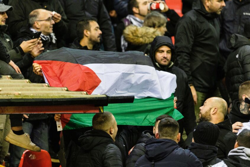 PAOK fans with a Palestine flag at Pittodrie.
