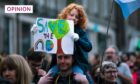 A COP27 climate change change demonstration in Edinburgh city centre, which saw several hundred people march from St Andrews Square and through the city. Pic shows Arabel Nelson, age 6, with her father, Robin, both from Edinburgh, on the march. Image: Andrew Cawley