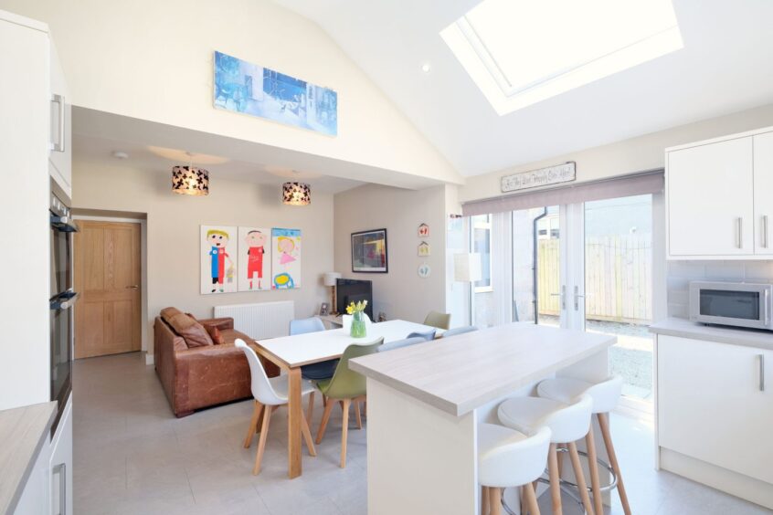 The west end property's kitchen, featuring high ceilings, Velux windows and doors to the back garden.