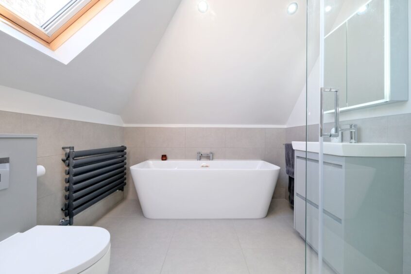 Large bathroom within the west end home, featuring a standalone bathtub and neutral colour scheme.