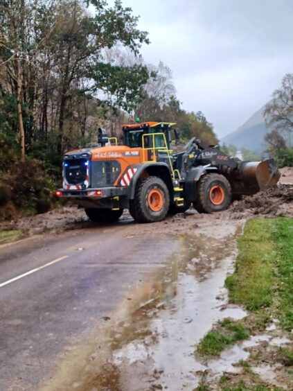 Tractor helps push away mud at A83 Butter Bridge/Glen Kinglas.
