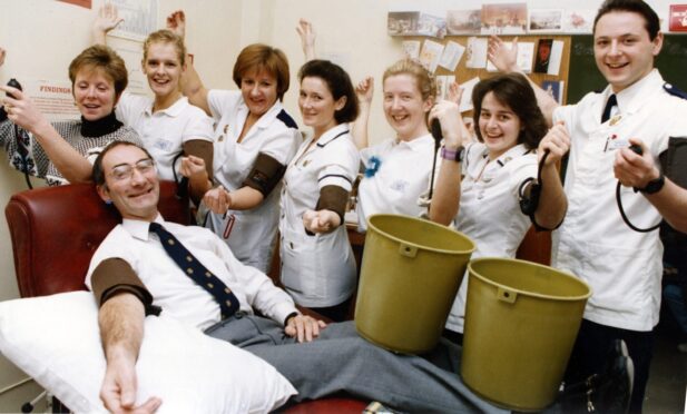 Woodend Hospital's Physiotherapy department finally decided to come to the transfusion department at ARI en masse to help publicise the need for blood during the festive season in 1991.  On the couch is regional director Dr Stan Urbaniak. Back, from left, Susan Massie; Lorna Nicol; Madelaine McPherson; Gillian Grant; Jenny Ingram, Susan Walker, and Neil Robinson. Image: DC Thomson