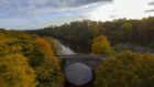 bird's eye view of a bridge and a river cutting across a green space in Aberdeen