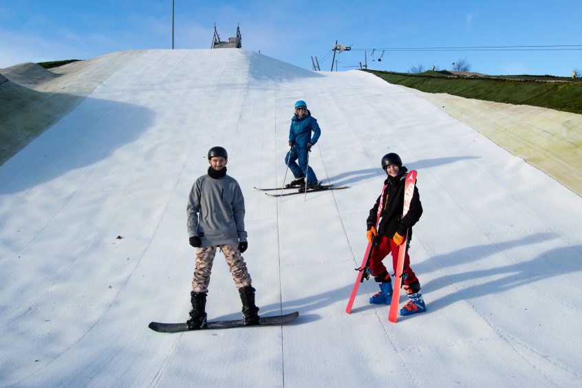 three skiers on the slopes at Adventure Aberdeen Snowsports Centre